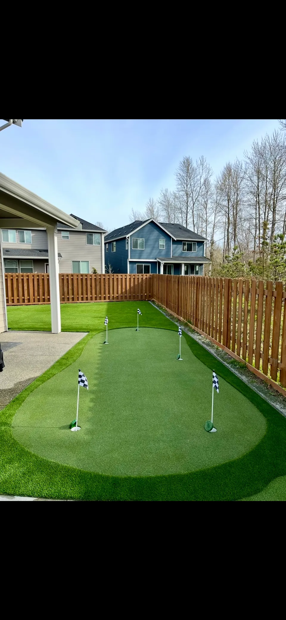 Fenced backyard with professionally installed artificial turf lawn