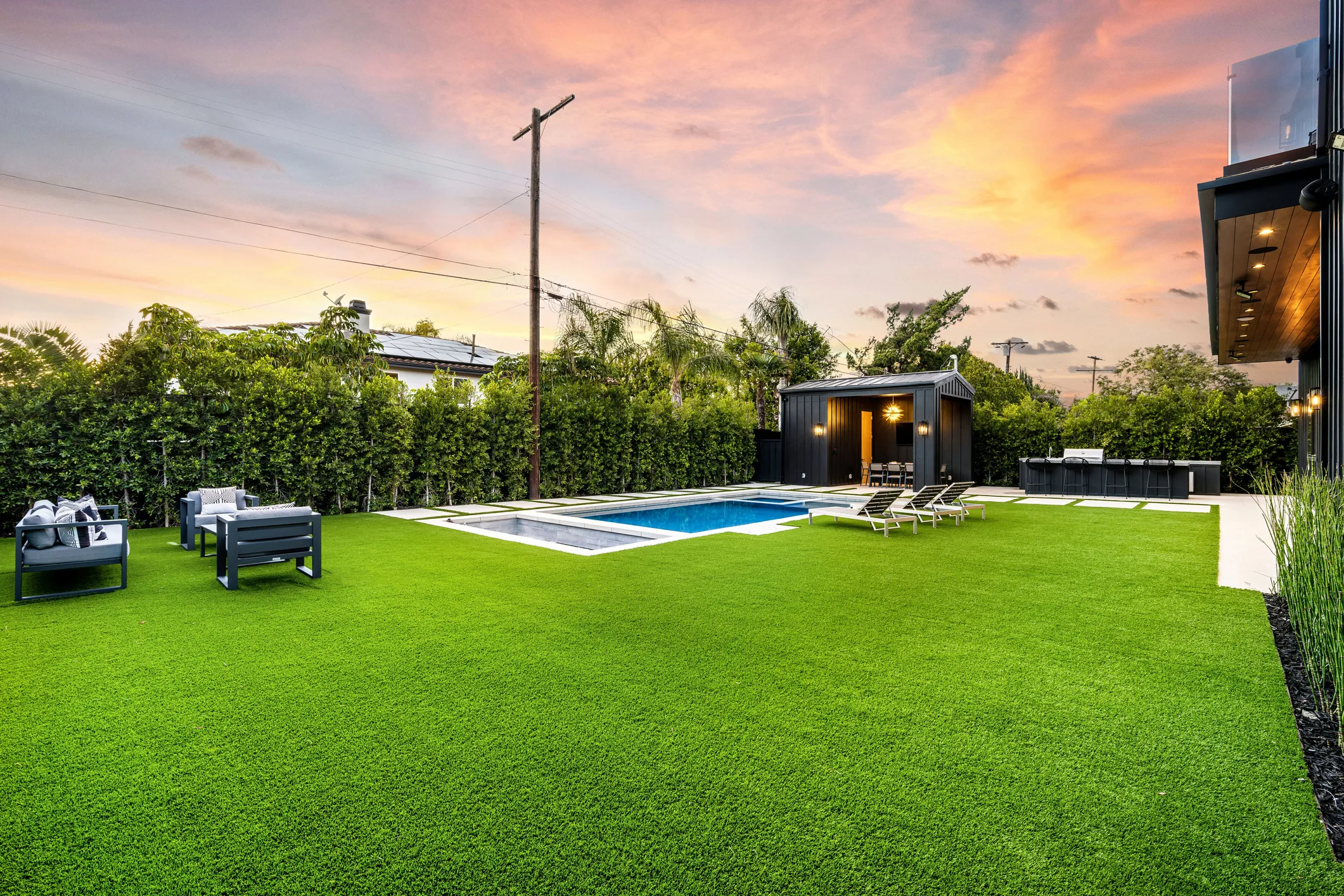 Artificial turf backyard with swimming pool and outdoor pool house