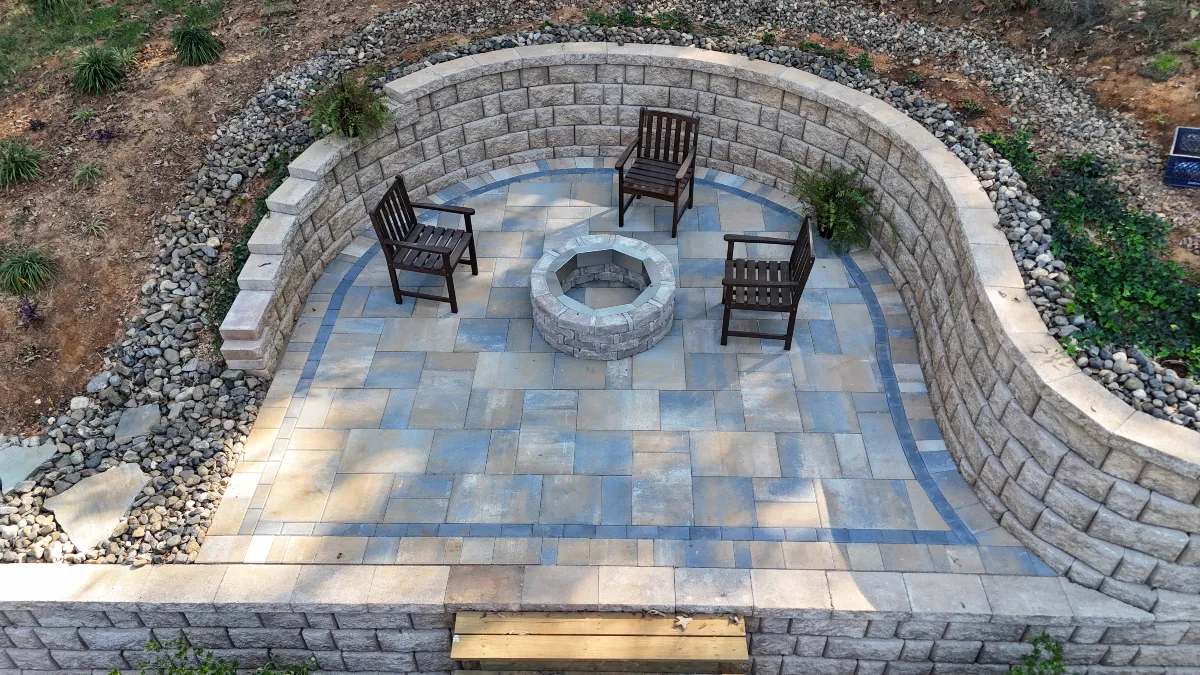 Custom circular paver patio with built-in fire pit and seating area