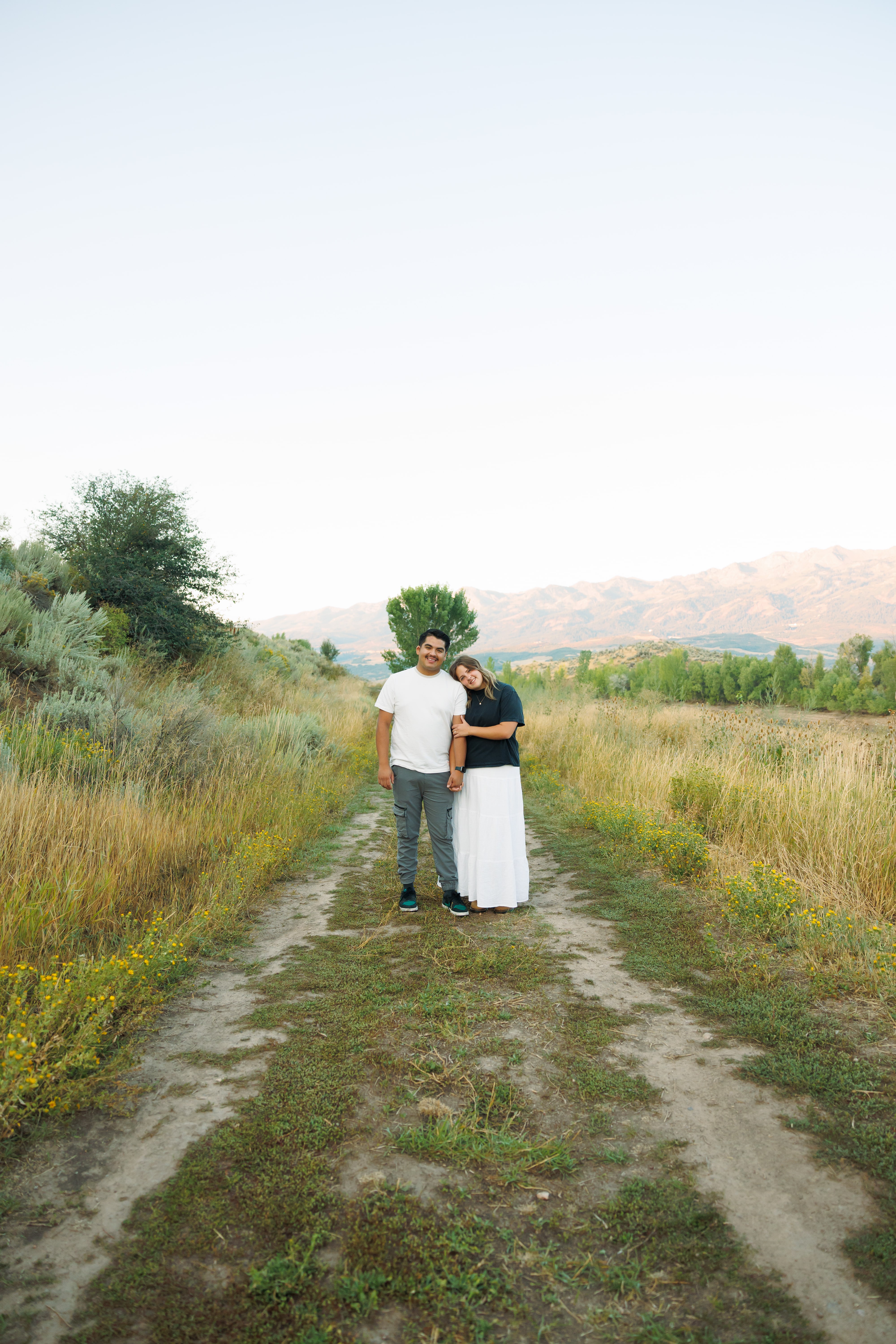 Couples photos shoot with mountain background in field | Wood Films Utah Photography & Videography