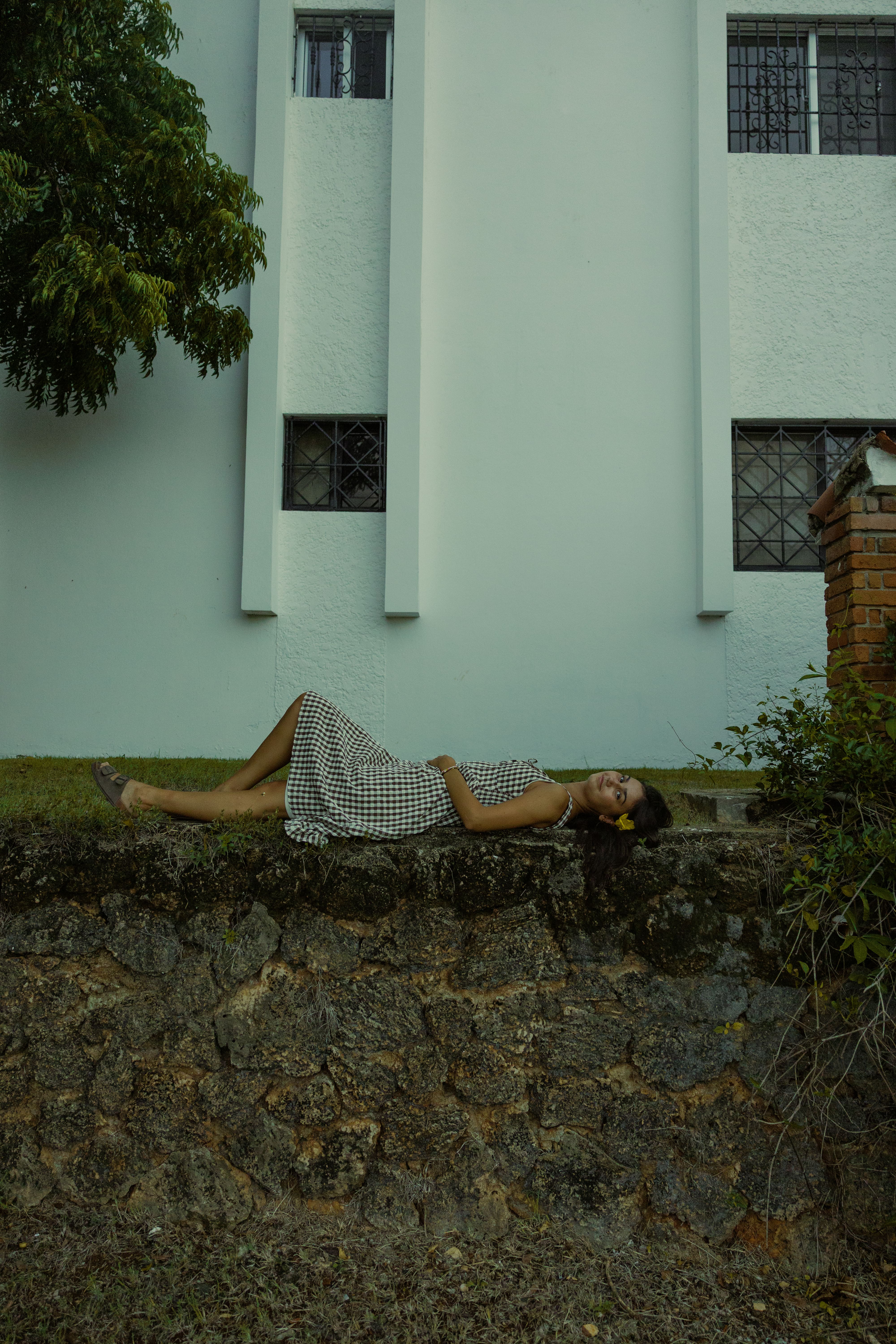 Girl in a dress laying on rock wall | Wood Films Utah Photography & Videography