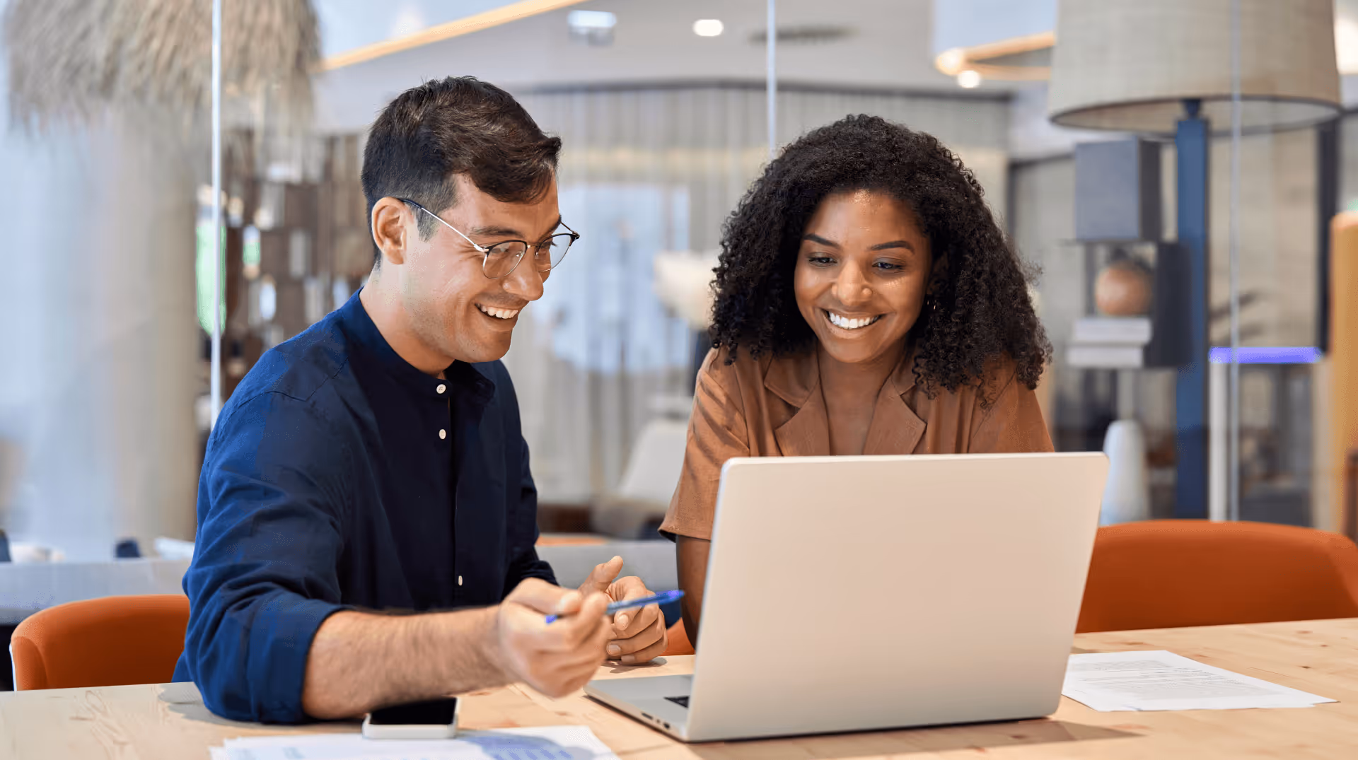 Man and a woman reviewing sensitive information over a laptop in a business setting