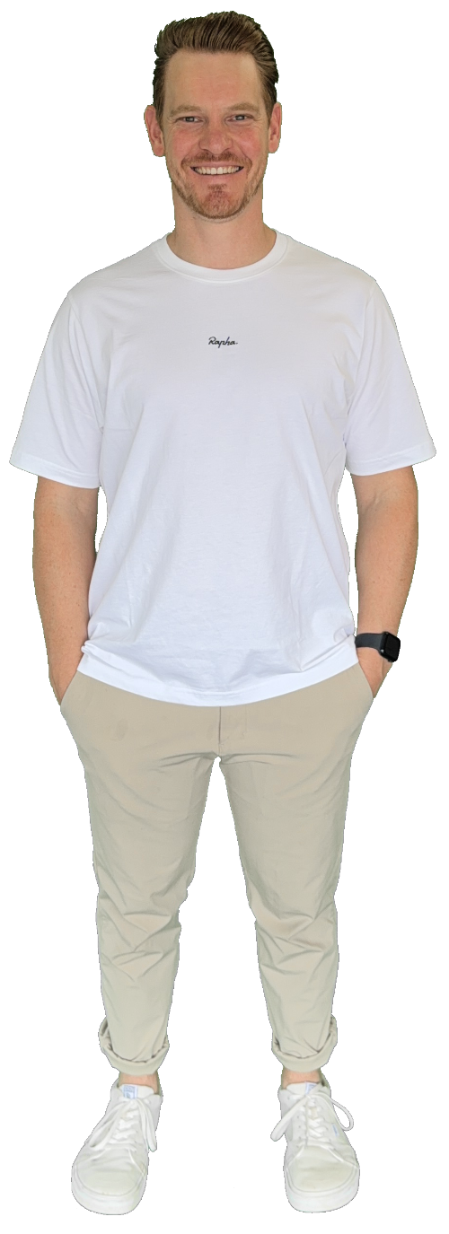 Me standing with hands in pockets wearing a white Rapha t-shirt, beige pants, white sneakers, and a black smartwatch.