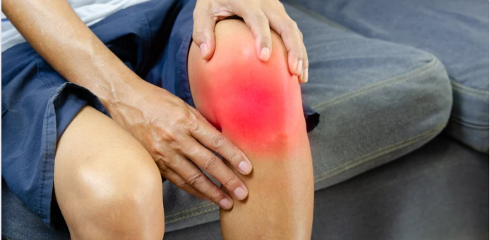 Person holding a knee with a red highlighted area indicating pain or injury