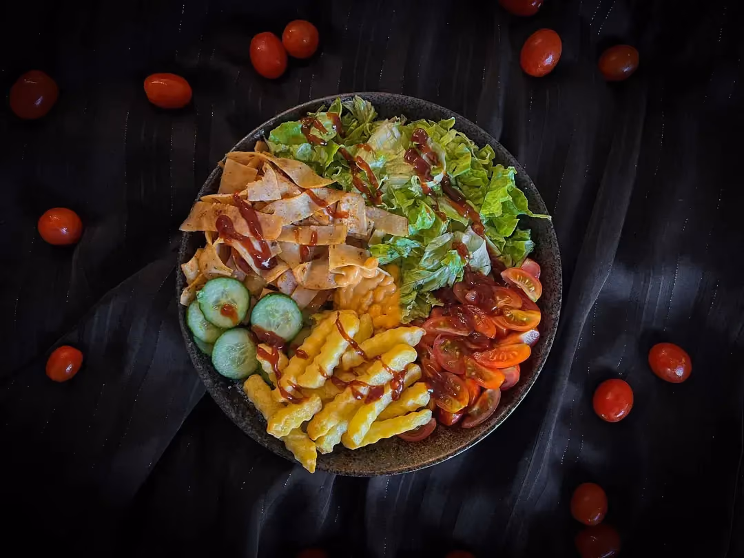 Un petit saladier de couleur bleu accueille le blanc de dinde, les frites, la salade iceberg et les tomates cerises.