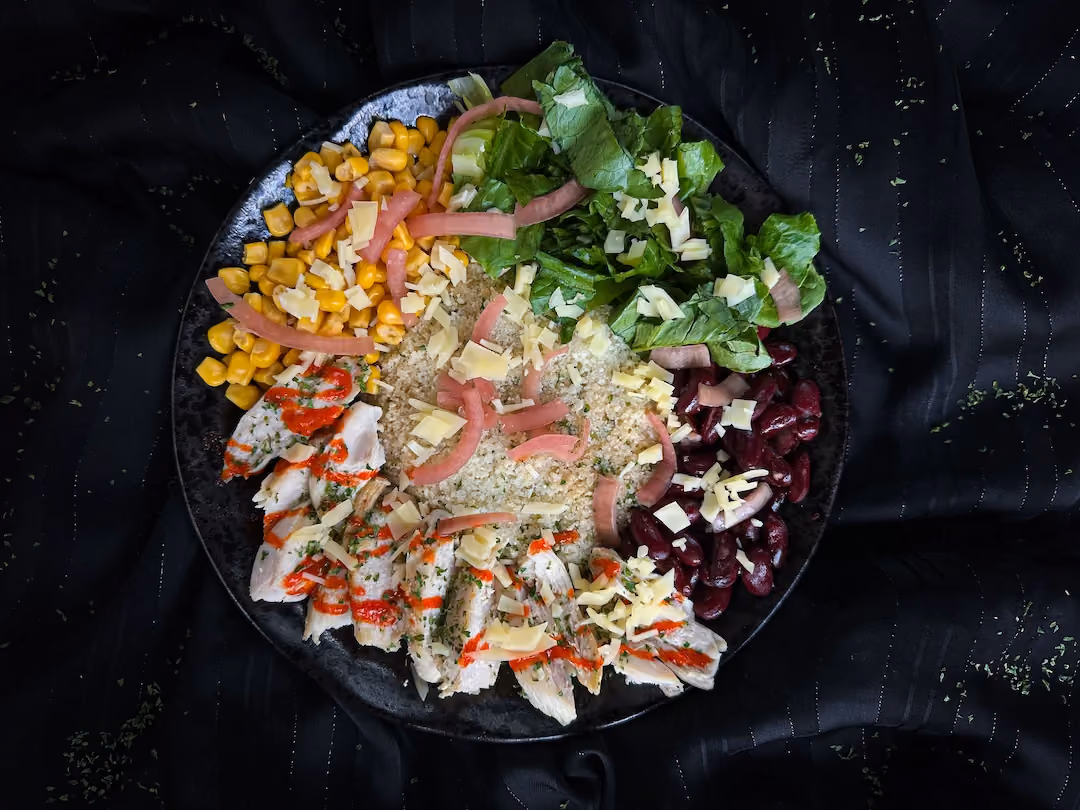 The Mexican chicken bowl with cauliflower rice, red beans, and corn is served in a blue earthenware bowl.