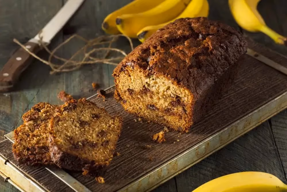 Sur une sorte de plaque de cuisson se trouve le banana bread protéiné. Quelques tranches sont déjà coupées.