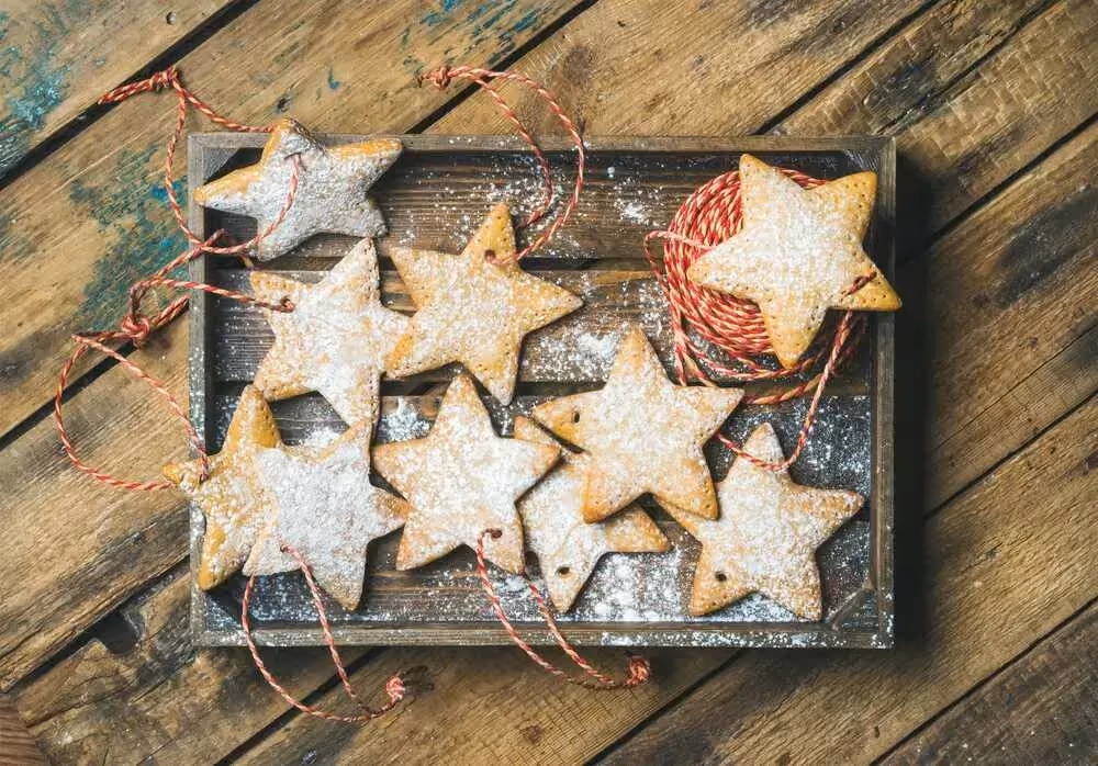 Sur un plateau rectangulaire sont déposés dix biscuits en forme d'étoile. Grâce à un petit trou, ils sont prêts à être accrochés sur le sapin de Noël.