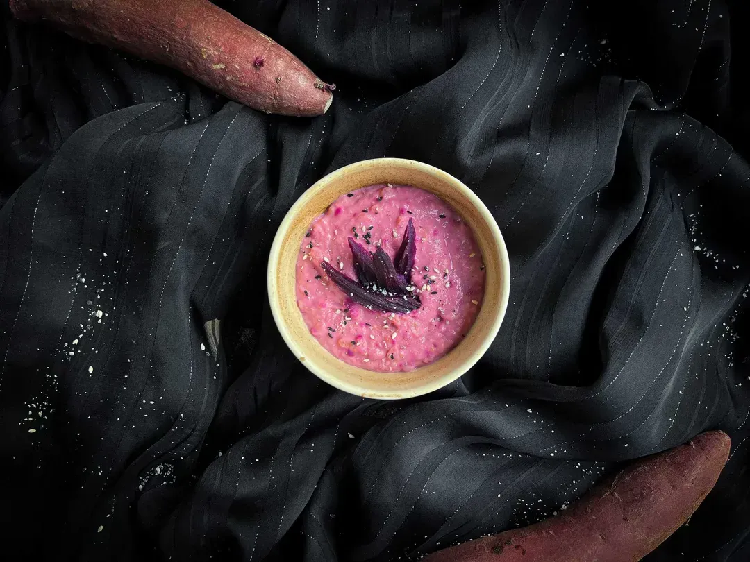 A small white stoneware bowl holds the express sweet potato bowl recipe. You can see the root vegetable's characteristic pinkish color.