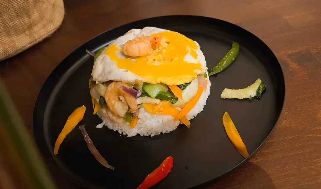 An upside-down bowl is placed in the middle of a dish. The different ingredients, such as peeled shrimp for example, are visible before our eyes.