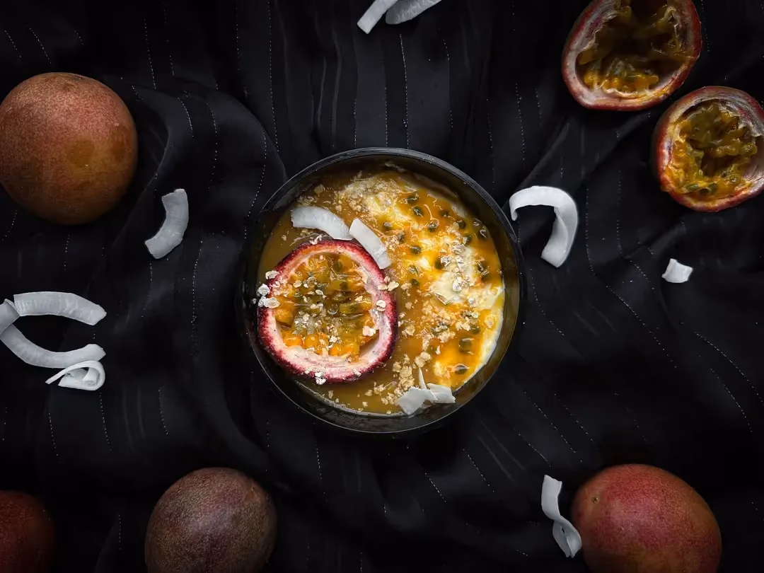 Posées dans un panier, se trouve deux verrines contenant le fromage blanc avec la purée de mangue et les fruits de la passion.