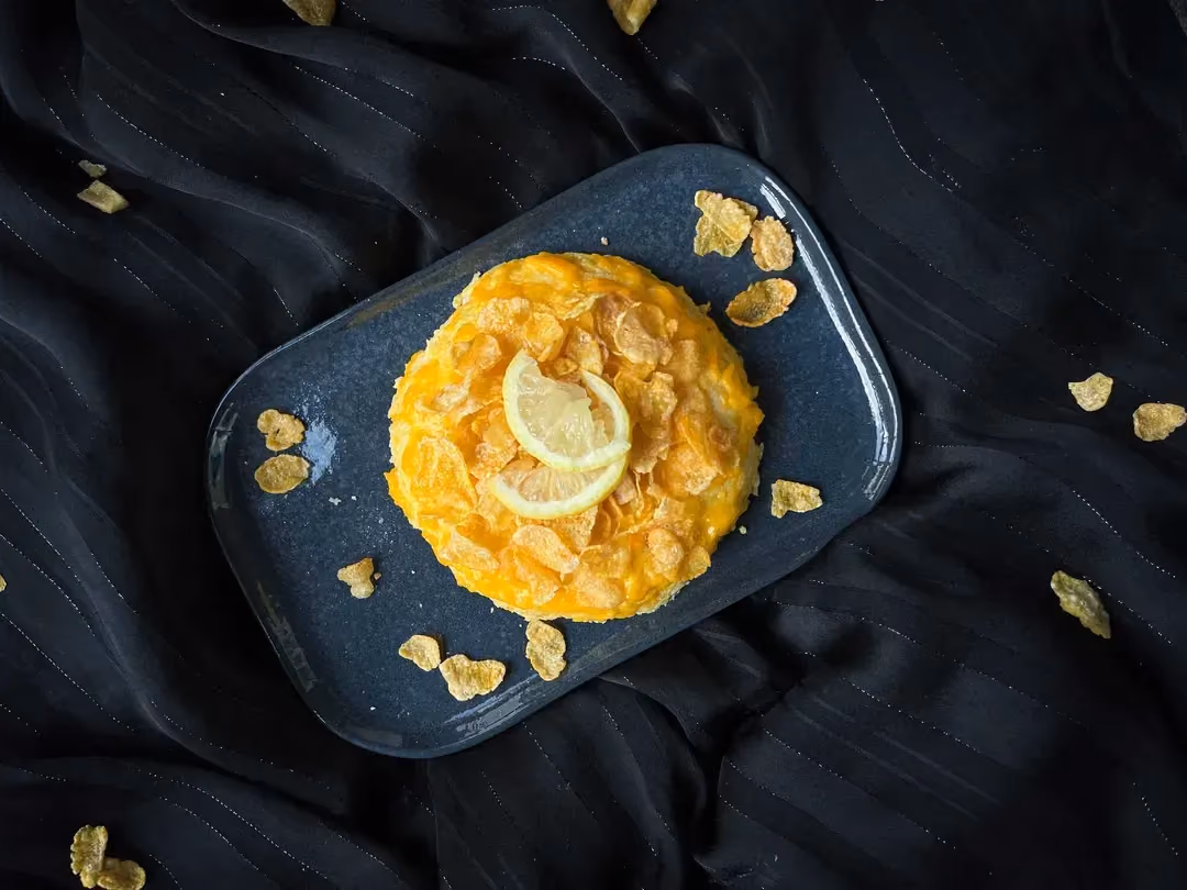 Le bowl cake citron et corn flakes, est présenté sur un plat peu profond de couleur bleu.