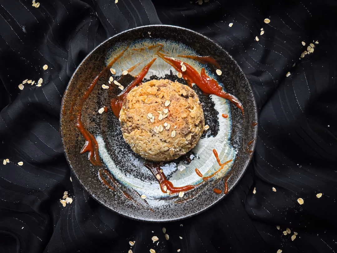 Sur une assiette de couleur blanche le bowl cake salé façon bolognaise montre en gros plan toute sa texture.