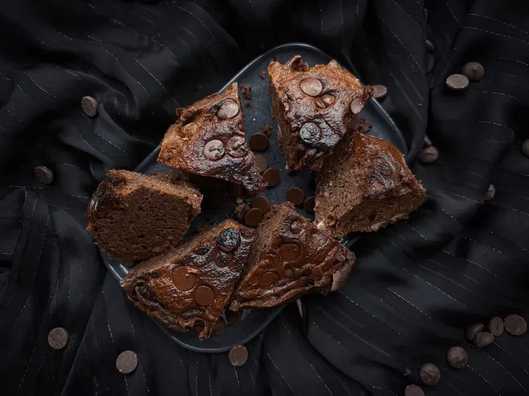 Deux belles parts de Brownie haricots rouges et chocolat sont superposées sur un plateau.