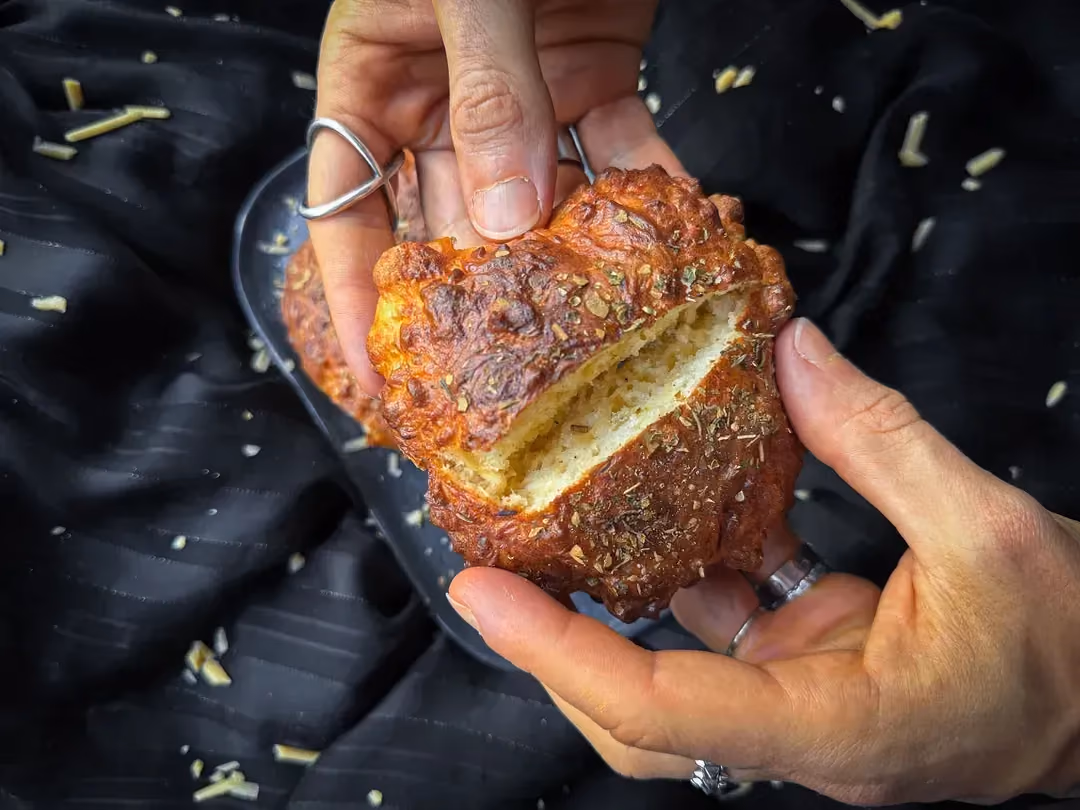 Dans mes mains se trouve un bun bien croustillant fourré avec de la mozzarella.