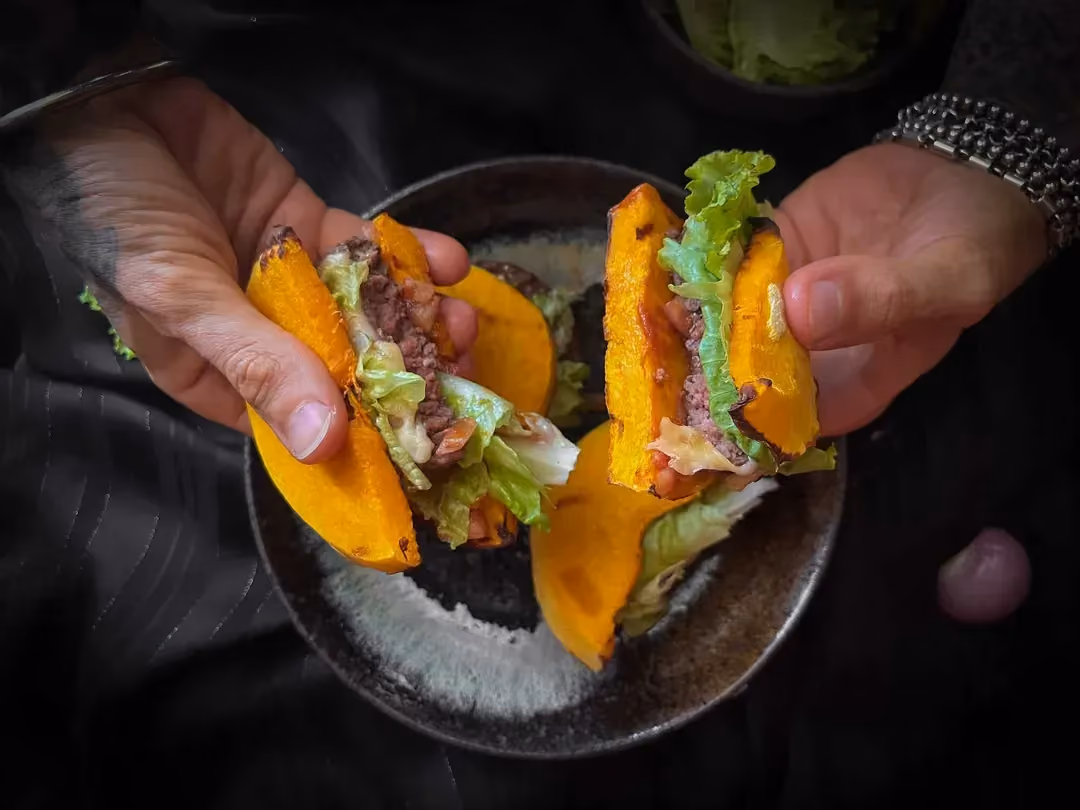 Dans mes mains se trouve un petit saladier avec la recette de burger de butternut avec le steak haché, la courge, le cheddar et la laitue iceberg.