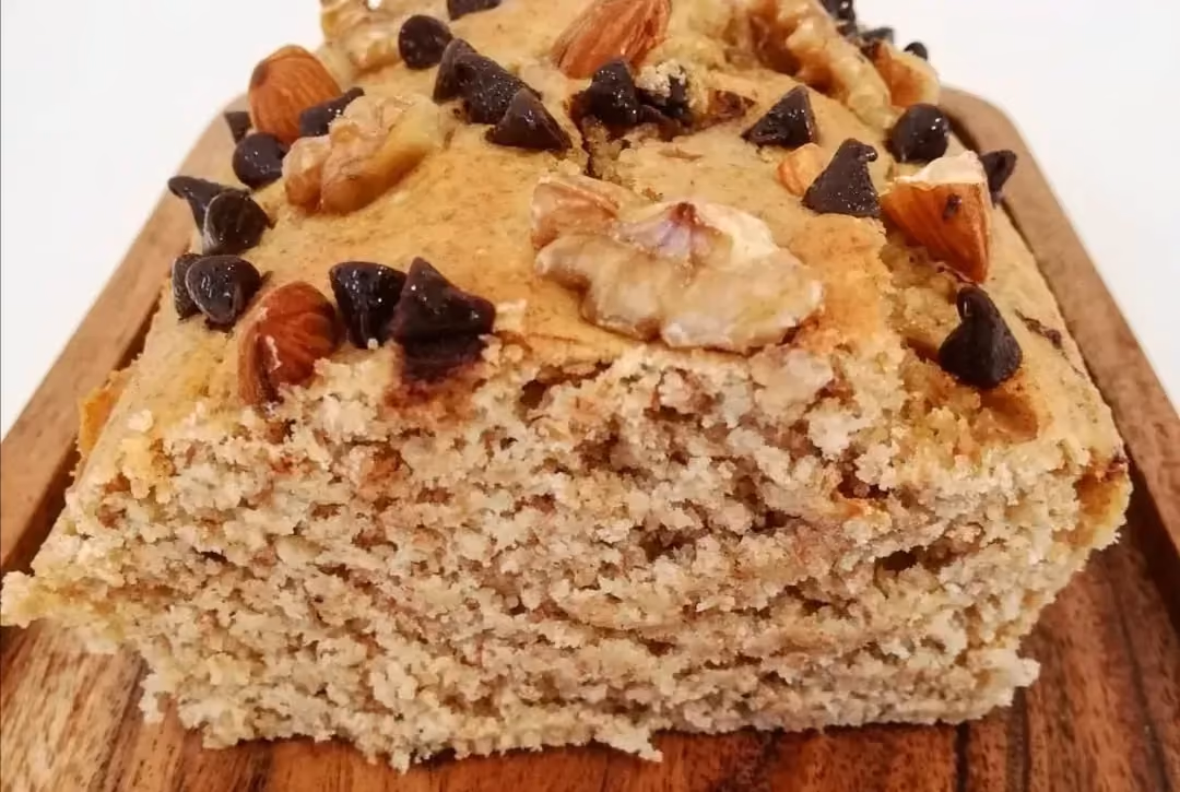 Sur un plateau en bois, on retrouve le Cakepote avec sa belle couleur ambrée. Le topping est composé de pépites de chocolat, d'amandes et de noix.
