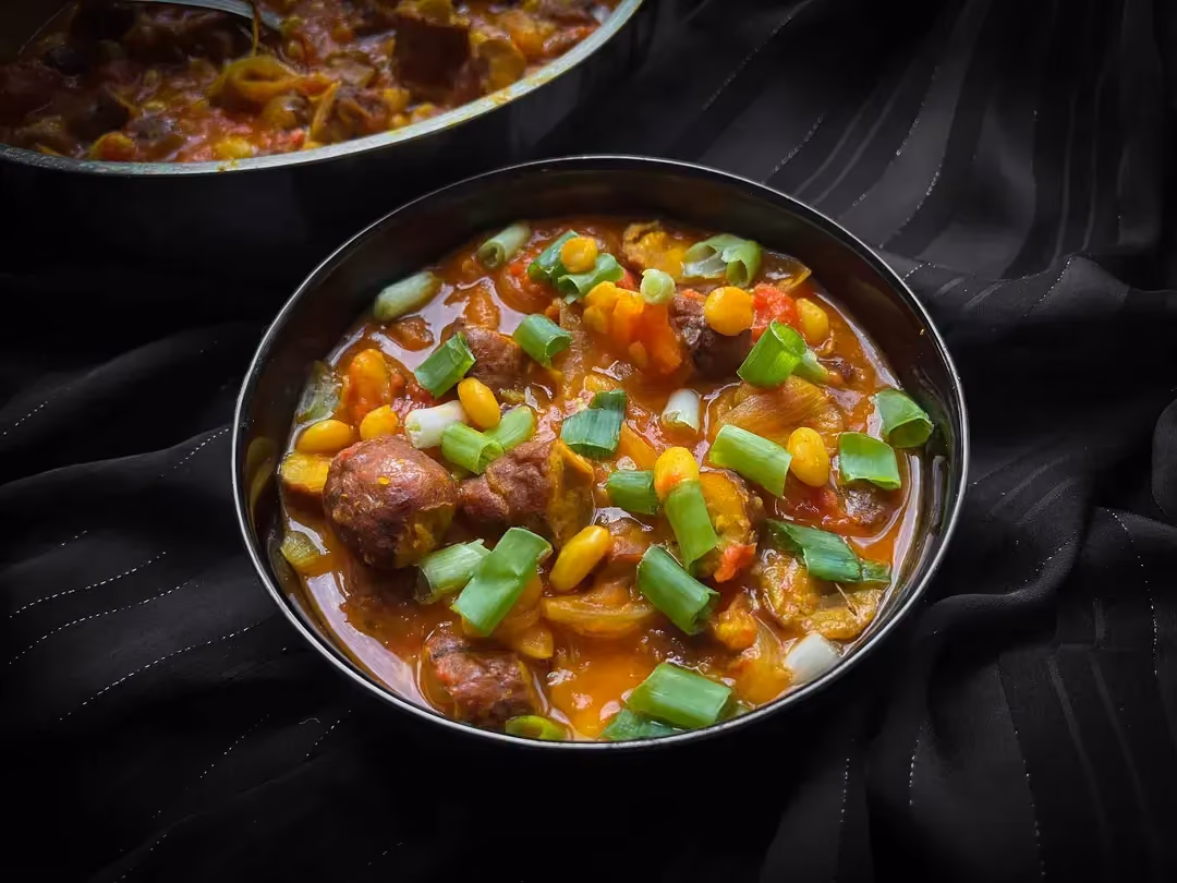 Le cassoulet à la créole avec ses saucisses de volaille et ses haricot blancs est présenté dans un petit saladier de couleur bleu.