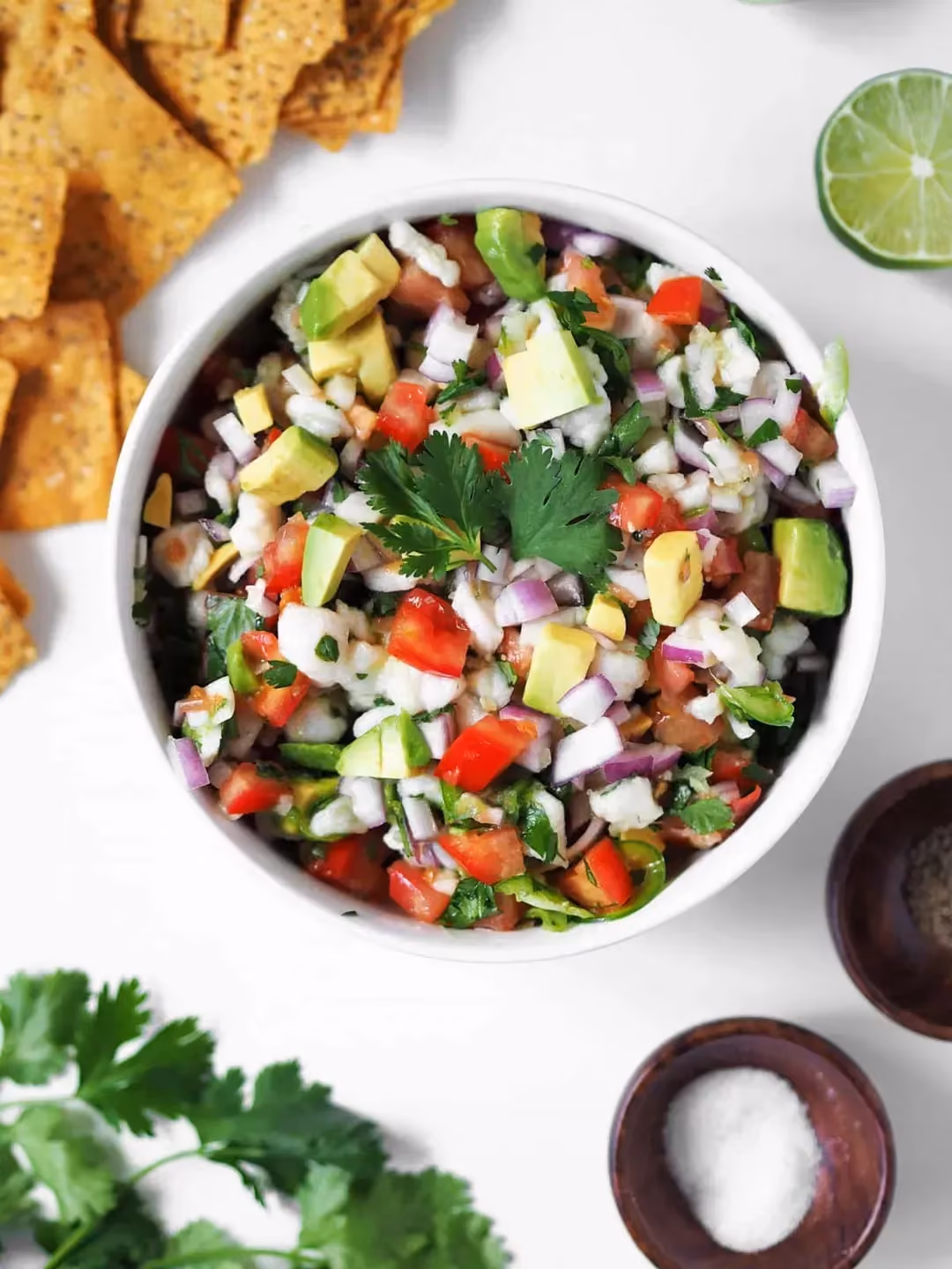 On retrouve cette recette de ceviche de tilapias dans un petit saladier en faïence blanc. Les ingrédients sont coupés en petits cubes et mélangés.