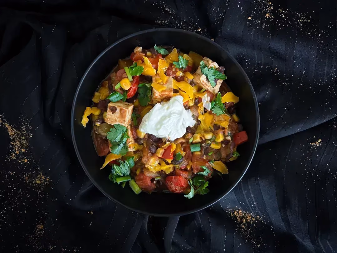 Un petit saladier en faïence de couleur bleu sert à présenter le recette de chili con tofu.