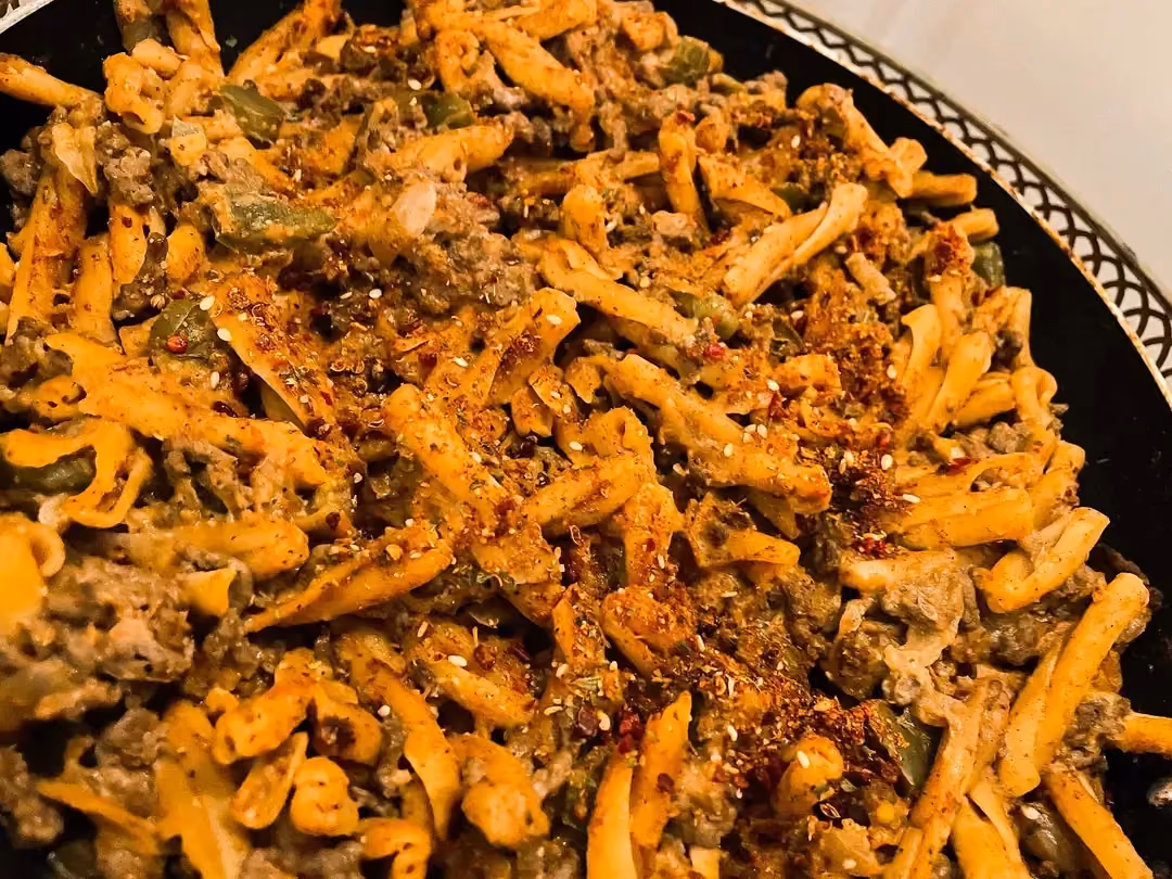 Dans un plat à gratin, les différents ingrédients de la recette ont pris la couleur des tomates et des épices pour le plus bel effet.