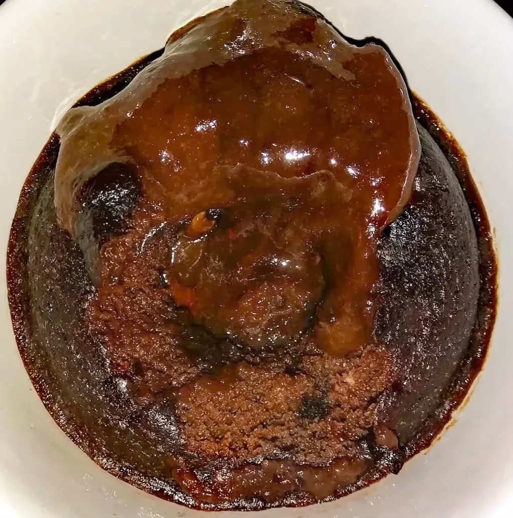 Sur une assiette de couleur blanche, ce coeur coulant au chocolat montre toute l'étendue de ses nuances de brun/marron. Effet visuel garantie.