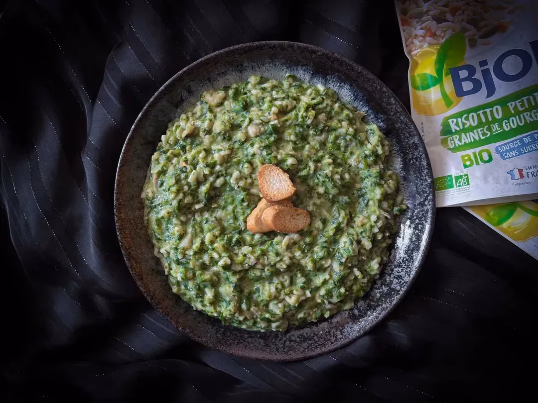 Pollock, rice, spinach, and Parmesan cream are presented in a blue bowl