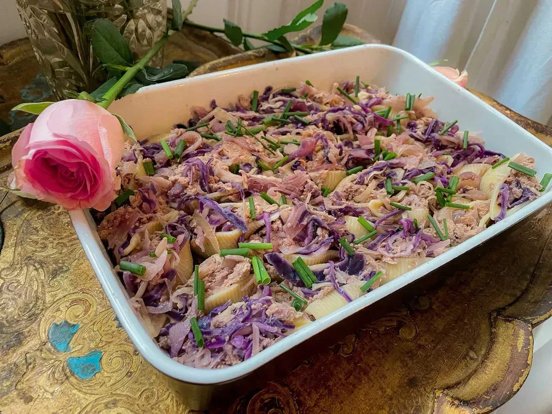 The conchiglioni are stuffed with tuna and red cabbage in a baking dish, decorated with roses.