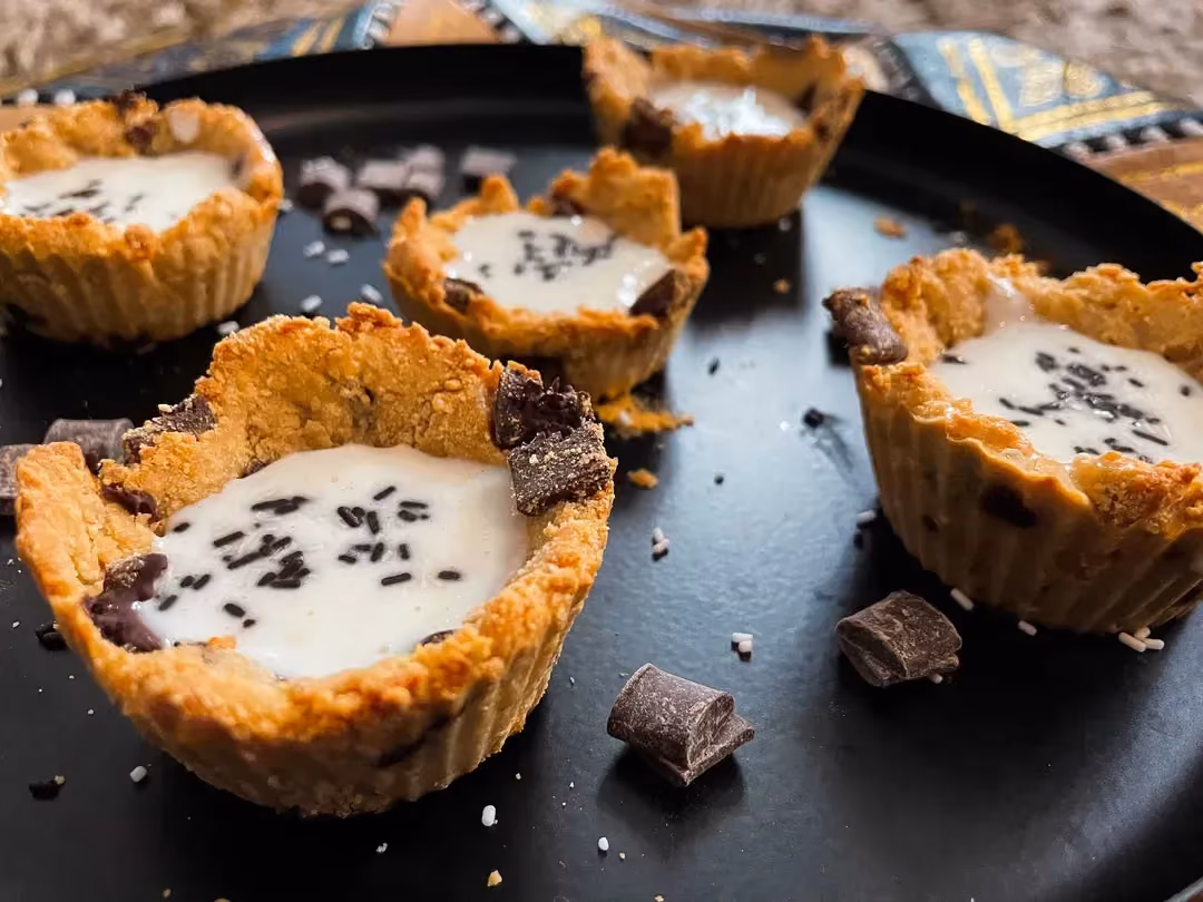 Cinq cookies cup qui ressemblent à de petits nids servent de réceptacle à la crème avec les pépites de chocolat.