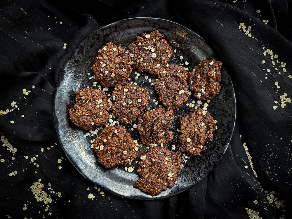 On a blue-and-white antique porcelain plate, the chocolate and banana cookies are arranged in a pyramid.