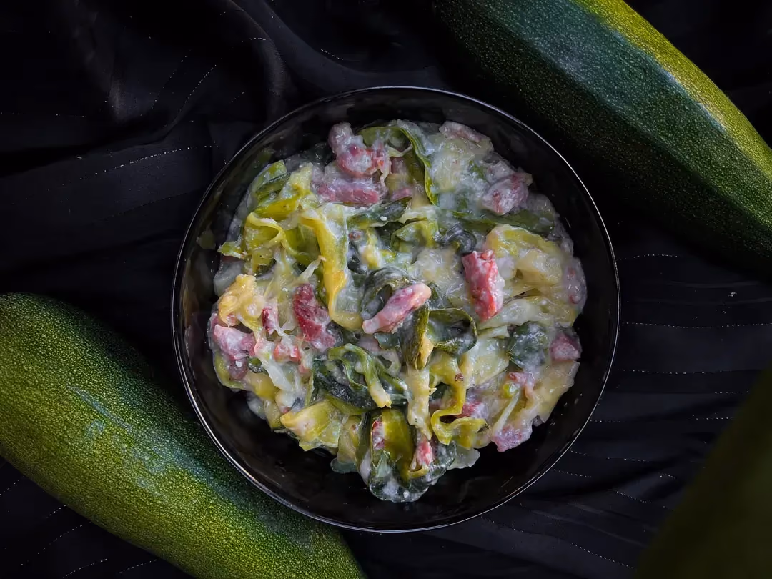 Dans un petit saladier se trouve les courgettes coupées en tagliatelles et les allumettes de bacon, le tout accompagné de crème fraiche épaisse.