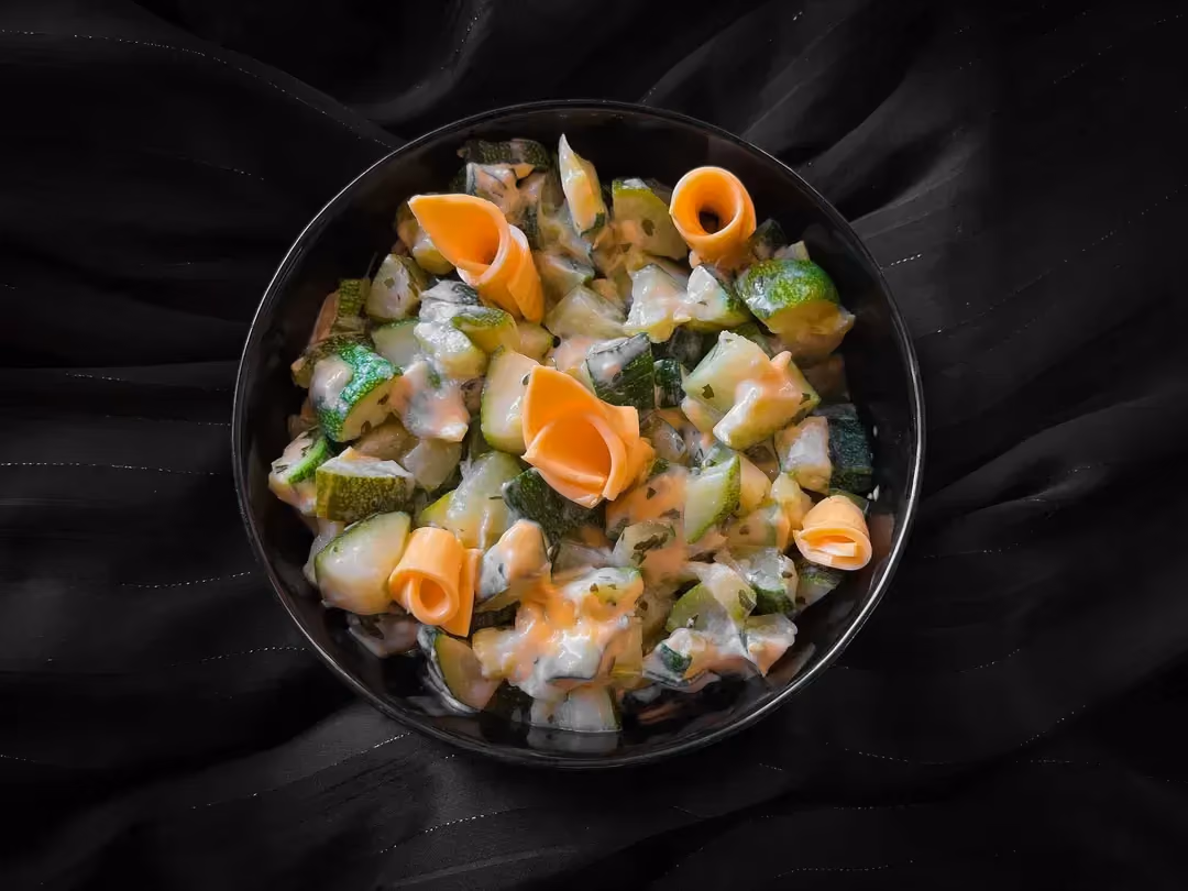 Dana un petit saladier se trouve les courgettes coupées en petites cubes enrobées de cheddar fondu.