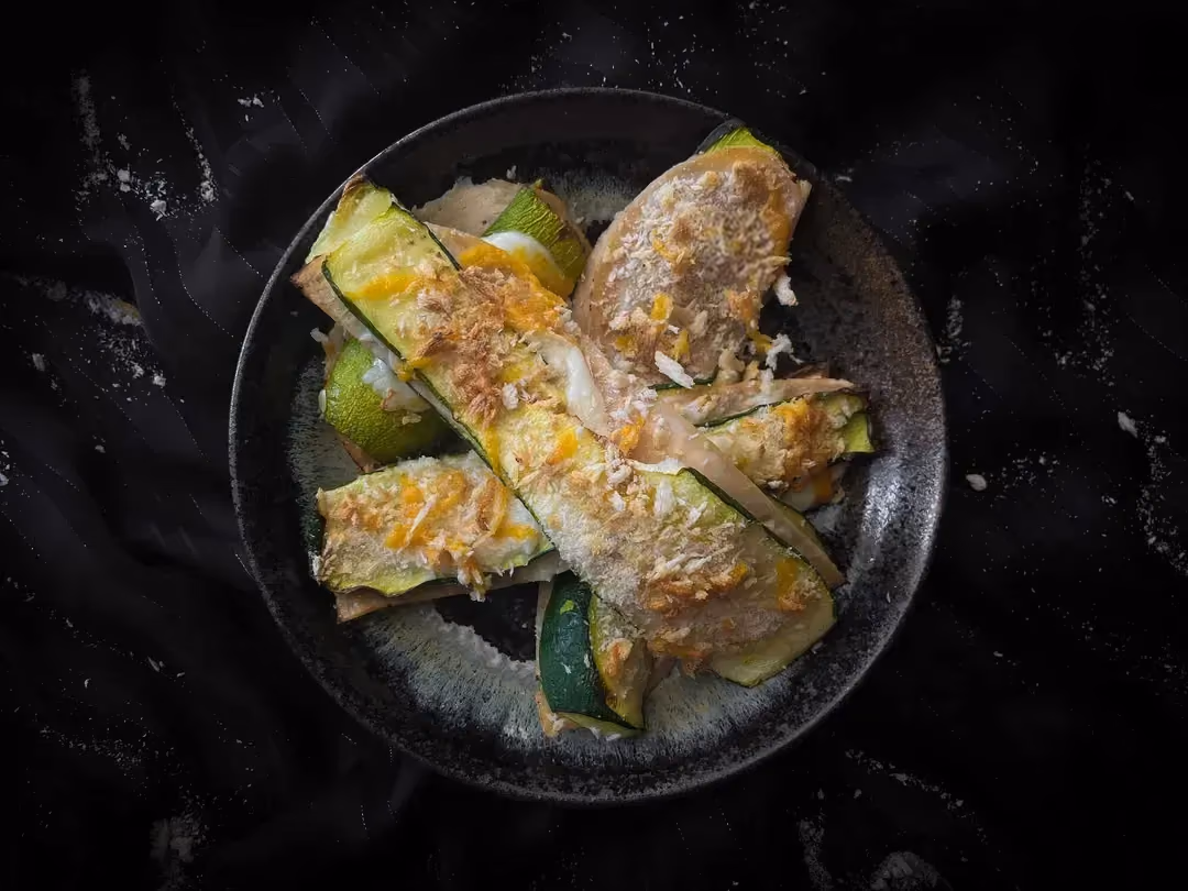 Quatre courgettes façon cordon bleu sont présentées dans un petit saladier de couleur bleu.