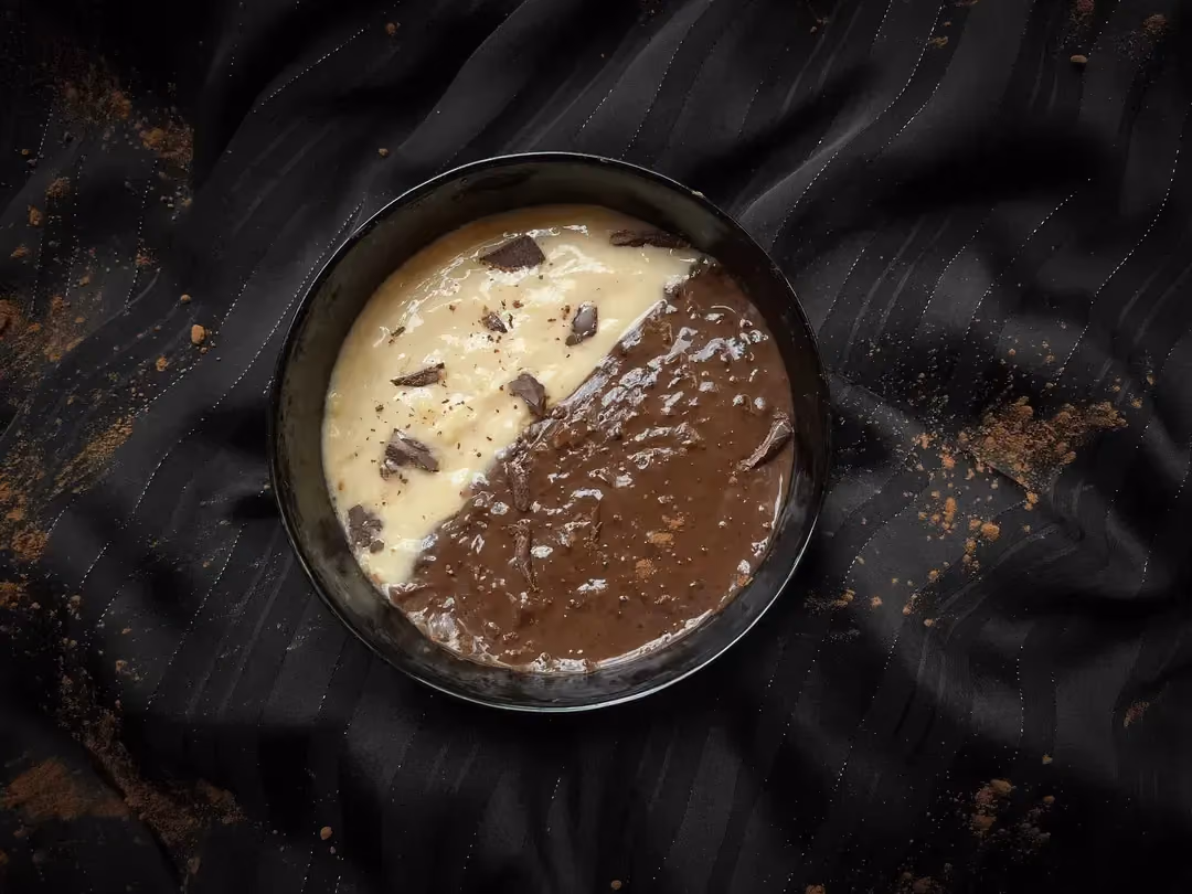 Dans un saladier se trouve la crème Arlequin protéinée. D'un côté la crème chocolatée et de l'autre sans chocolat, pour un bel effet bicolore.