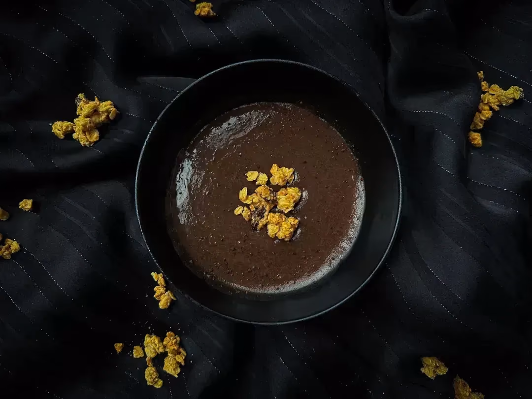 Un petit saladier recueille la crème dessert au chocolat.