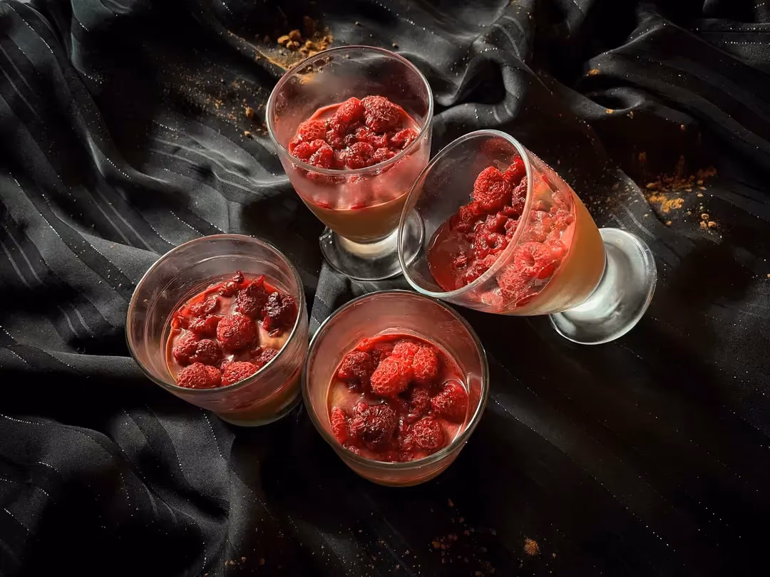 Quatre verres à pied accueillent la crème dessert chocolat et framboises. Effet visuel garantie !