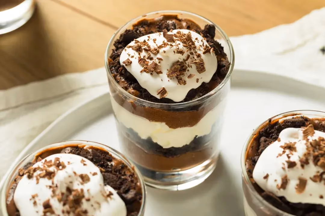 Disposé dans trois grands verres, on retrouve les couches alternées de crème vanille et de chocolat et sur le dessus le brownie émietté.
