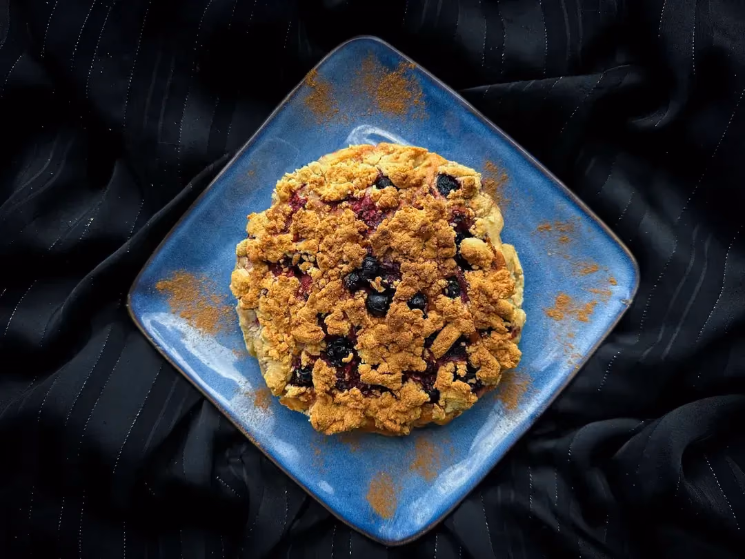 Le crumb cake est présenté sur un plat de forme carré en faïence de couleur bleu.