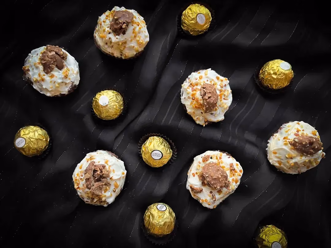 Six petits cupcakes sont accompagnés par sept Ferrero Rocher.