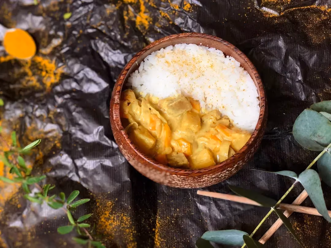 Dans un grand bol en faïance, on retrouve d'un côté l'ananas et le seitan coupé en petits morceaux, et de l'autre côté du riz.