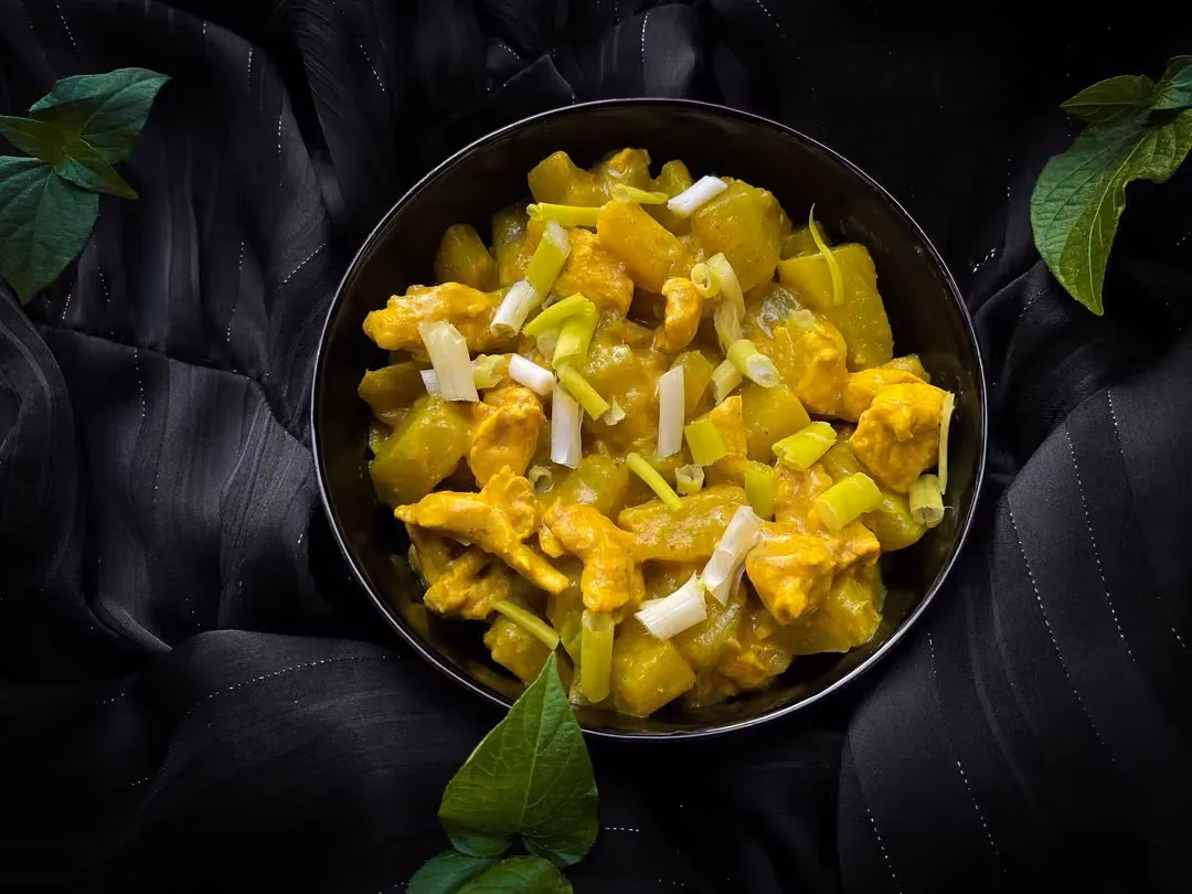 Dans un petit saladier, les christophines et le poulet coupés en petits morceaux ont une jolie couleur jaune dû à la présence du curry.