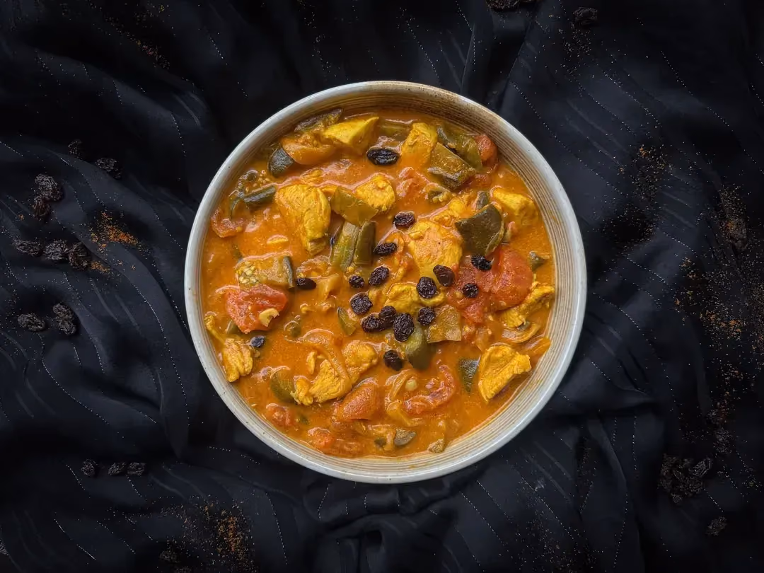 In a large mixing bowl, the garam masala has beautifully colored the grilled chicken and eggplant.