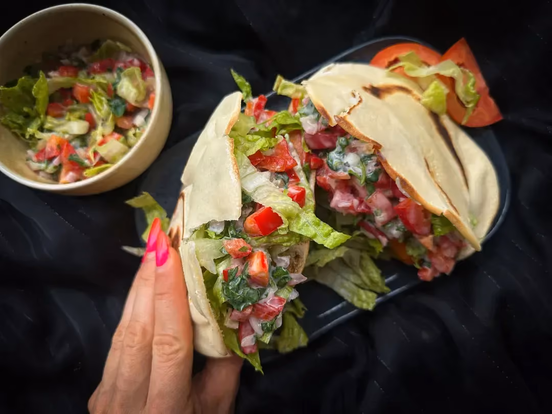 L'assiette contenant le kebab de veau maison est posée sur une serviette bleue et blanche. Le kebab est posé sur une sorte de galette.