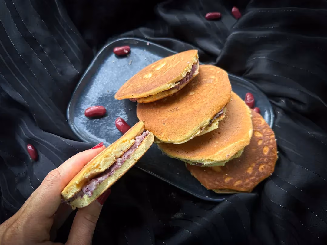 Ces petits pancakes sont fourrés de pâte de haricots rouges avec en arrière plan des fleurs de cerisiers.