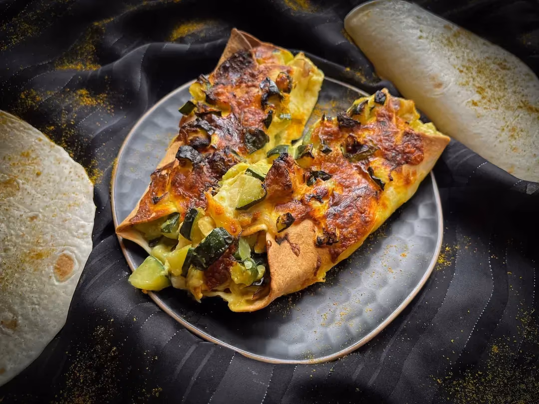 Deux tortillas contiennent du poulet, des courgettes et de la mozarella.