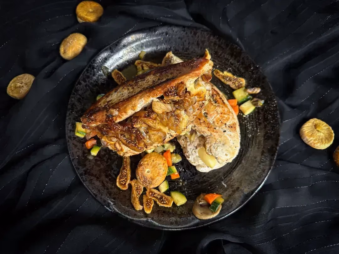The chicken cutlet stuffed with Brie and dried figs is presented like a sandwich.