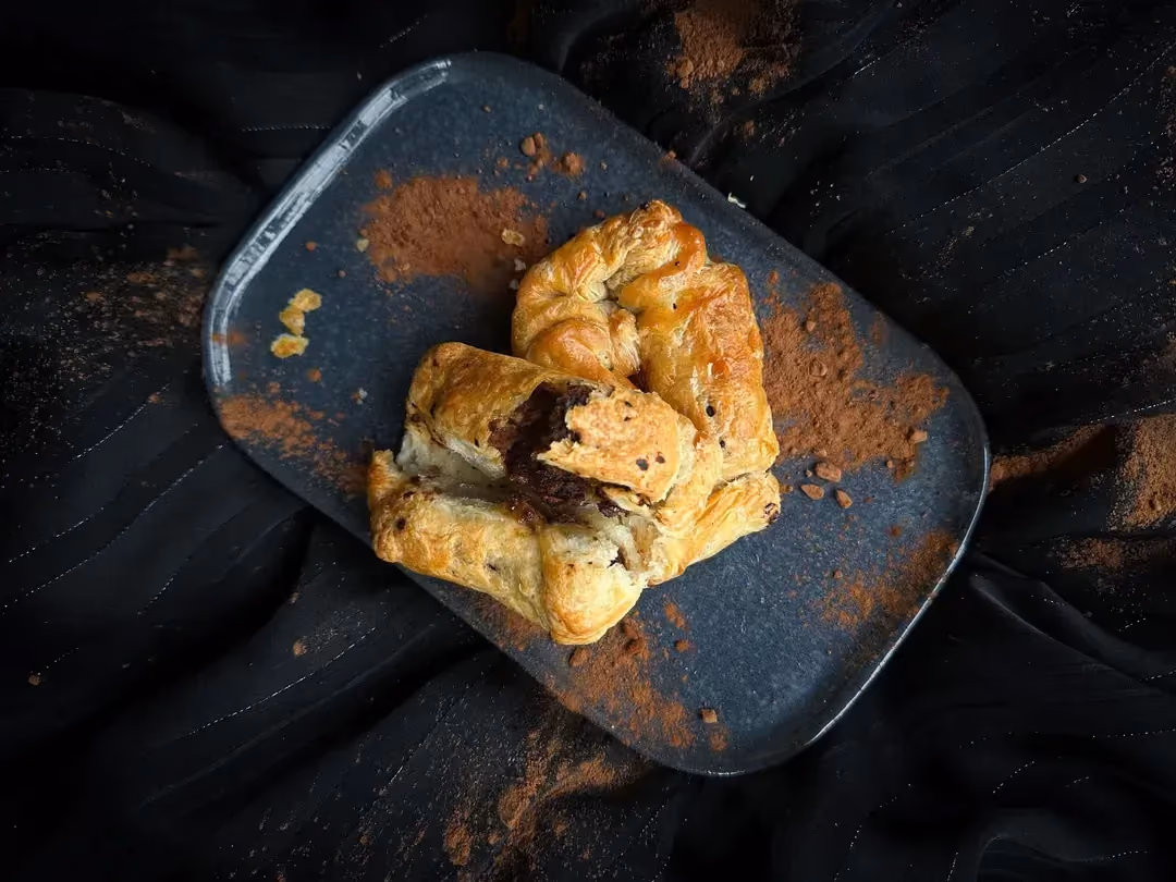 The chocolate protein pastry is presented on a blue rectangular plate.