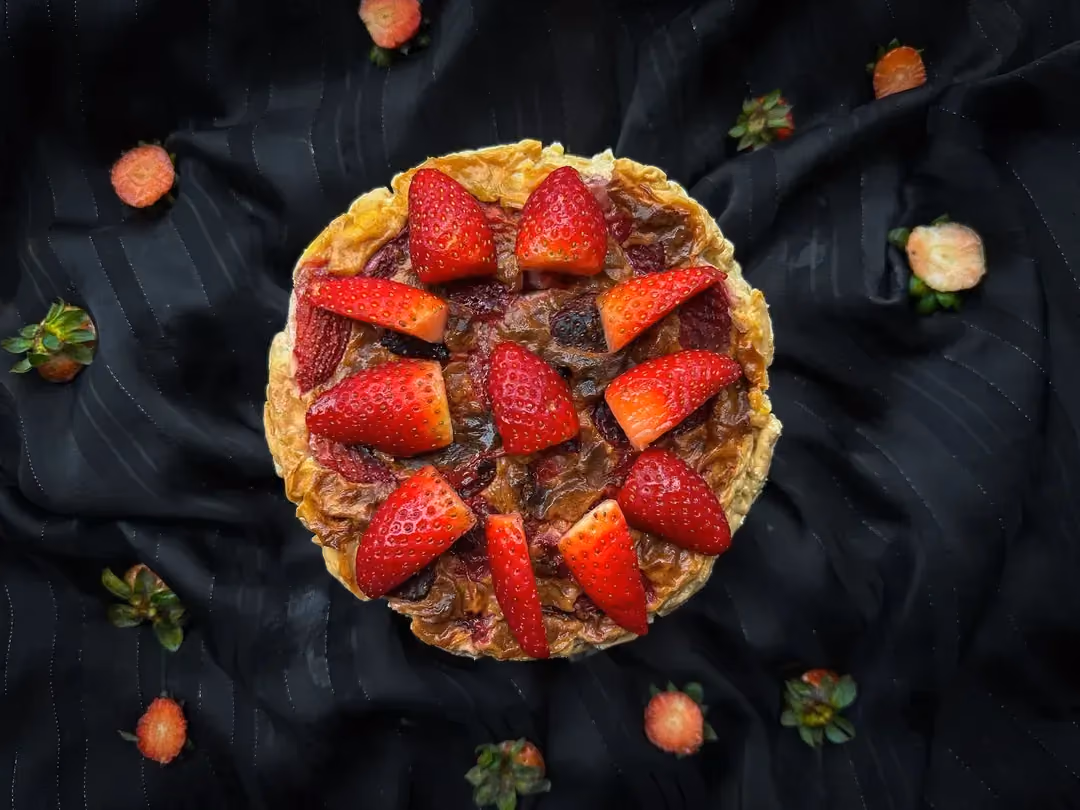 De gros morceaux de fraises servent de topping sur la recette de flan aux fraises.