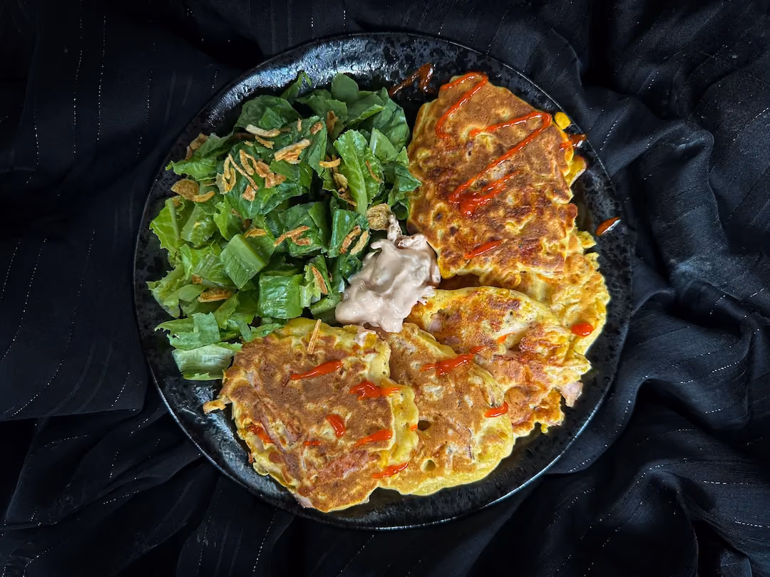 The corn, cheddar, and ham fritter recipe is presented in a small blue bowl.