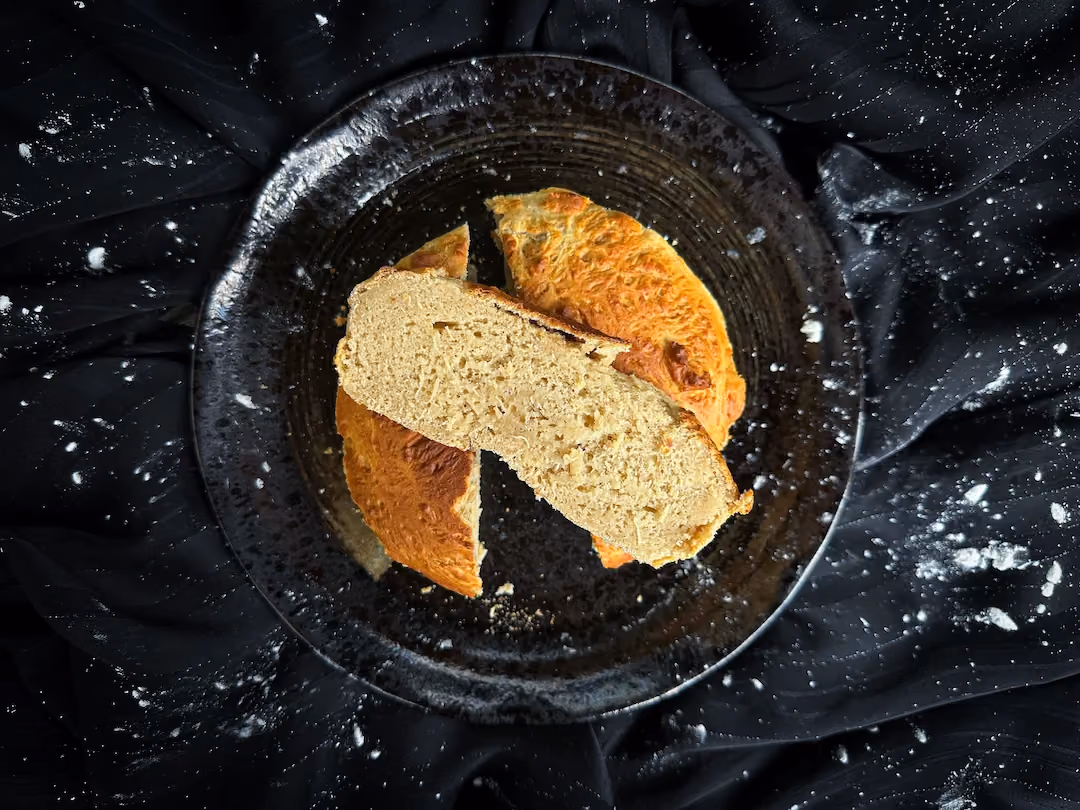 Présenté sur une assiette de couleur blanche se trouve le gâteau façon brioche bien doré en forme de coeur.